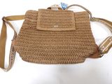 beige crocheted purse with leather strap on white background