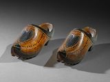 pair of wooden shoes with holes on them sitting on a table