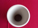 a white cup sitting on a pink table cloth
