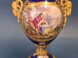a blue vase with a painting on it sitting on a table