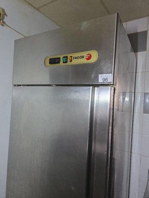 un réfrigérateur en acier inoxydable dans une cuisine, avec une affiche sur la porte