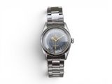 an image of a watch on a metal bracelet on a white surface