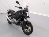 une moto noire garée dans une pièce aux murs blancs