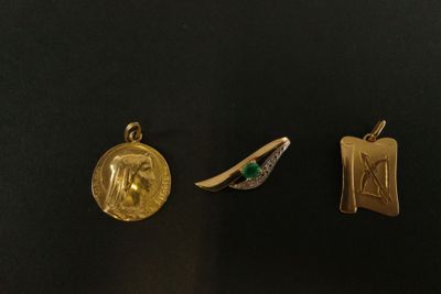 trois pendentifs en or et émeraude sur un fond noir