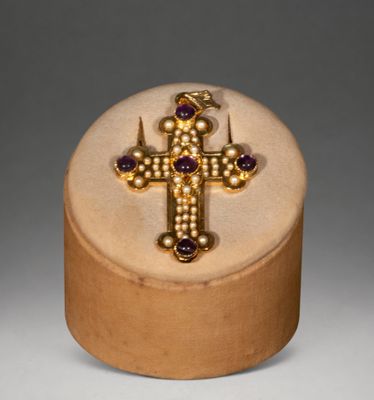 gold and amethoral cross with amethoral stones in a wooden box
