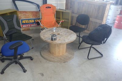 plusieurs chaises et une table dans une pièce où se trouvent de nombreux cartons