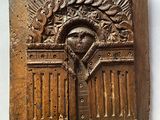 une photo d'une plaque en bois sur laquelle figure l'image d'un homme dans une entrée