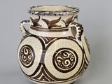 un vase brun et blanc posé sur une table