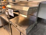 a metal counter with a sign on it in a kitchen