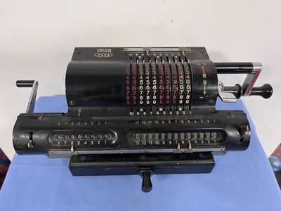 une vieille machine à écrire posée sur une table bleue