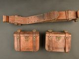 trois morceaux de cuir marron munis de boucles en laiton sur un fond gris