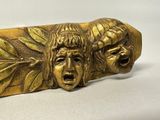 a gold sculpture of a man and a woman with faces on it