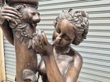 a bronze statue of a man and a woman sitting on a bench