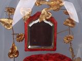 a red rose in a glass dome with a gold bird on it