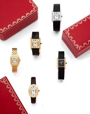 un assortiment de montres et une boîte rouge posée sur un fond blanc
