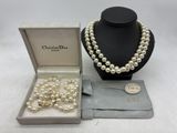 une photo d'un collier et de boucles d'oreilles en perles blanches dans un écrin