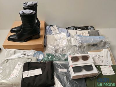 une boîte de vêtements et une paire de bottes noires posées sur une table
