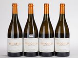 trois bouteilles de vin posées l'une à côté de l'autre sur une table