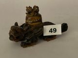 une petite figurine représentant un chien, à laquelle est accrochée une médaille