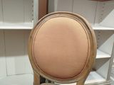 the back of a chair with a beige upholstered seat