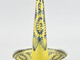 un vase jaune et bleu surmonté d'un oiseau