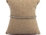 un gros plan sur un oreiller sur lequel repose un bracelet en diamants