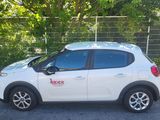 a picture of a white car parked in front of a fence