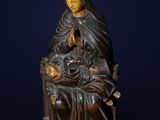 une statue représentant une femme tenant un enfant sur ses genoux