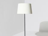 Le lampadaire est doté d'un pied noir et d'un abat-jour blanc.