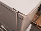 a white refrigerator sitting on top of a wooden pallet