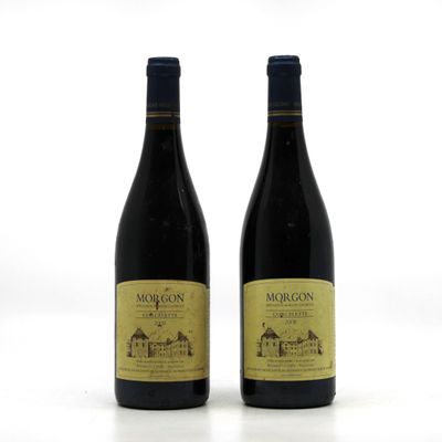 two bottles of red wine sitting next to each other on a white surface