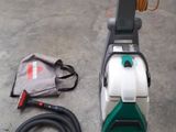 a green and white vacuum cleaner on the floor