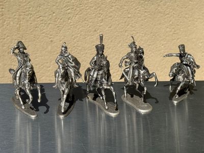 five figurines of men riding on surfboards on a table