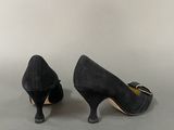 pair of women ' s black sued pumps with gold buckles