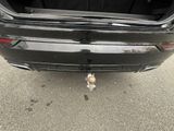 the back end of a car with its trunk open on the street
