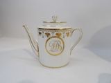 an image of a white and gold tea pot with a monogram on it