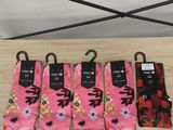 quatre paires de chaussettes roses ornées de fleurs noires et rouges