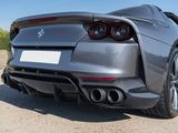 the rear end of a silver sports car parked in a parking lot