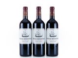 trois bouteilles de vin rouge posées l'une à côté de l'autre sur une surface blanche