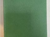 a green book sitting on top of a white table