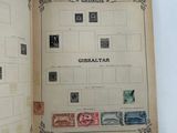 an open book with stamps on it on a white surface