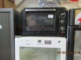 a microwave oven sitting on top of a refrigerator next to other appliances