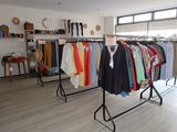 a lot of clothes hanging on a rack in a room