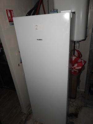 a white refrigerator in the corner of a room with a fire hydrant in the corner