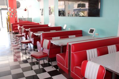 des tables et des banquettes dans un restaurant au sol à carreaux et aux murs bleus