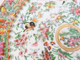 a close up of a plate with birds and flowers on it