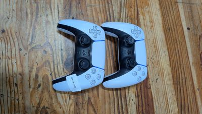 deux manettes de jeux vidéo posées sur un parquet
