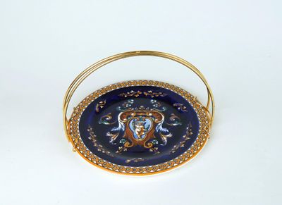 une assiette bleue avec une poignée dorée sur un fond blanc