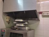 a silver microwave sitting in a kitchen with a pot on the stove