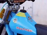 a blue dirt bike parked in front of a building
